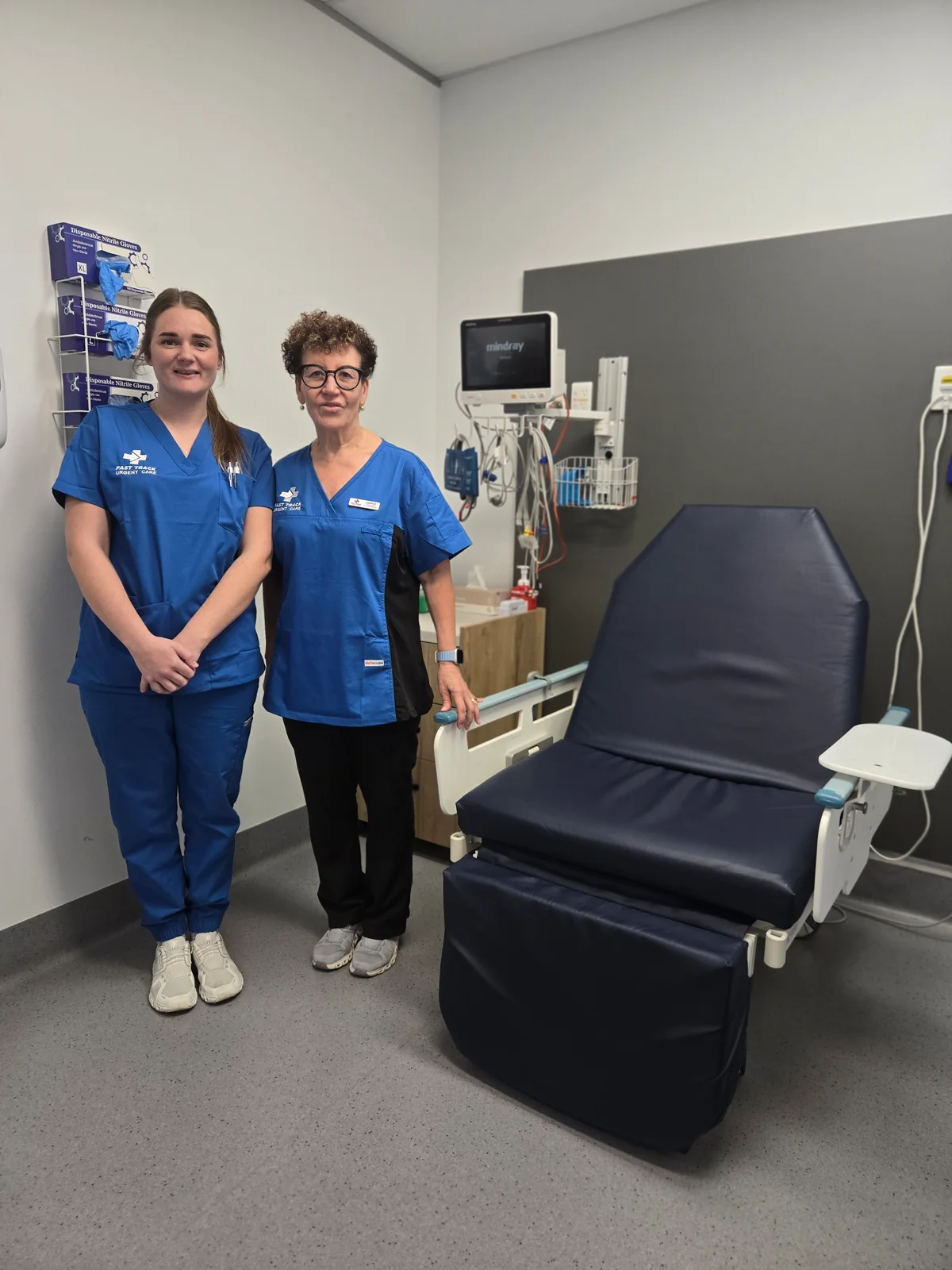 Two Fast Track team members beside a clinic treatment chair
