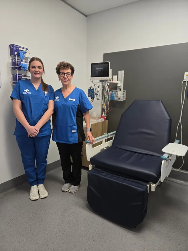Two clinic team members beside a treatment chair
