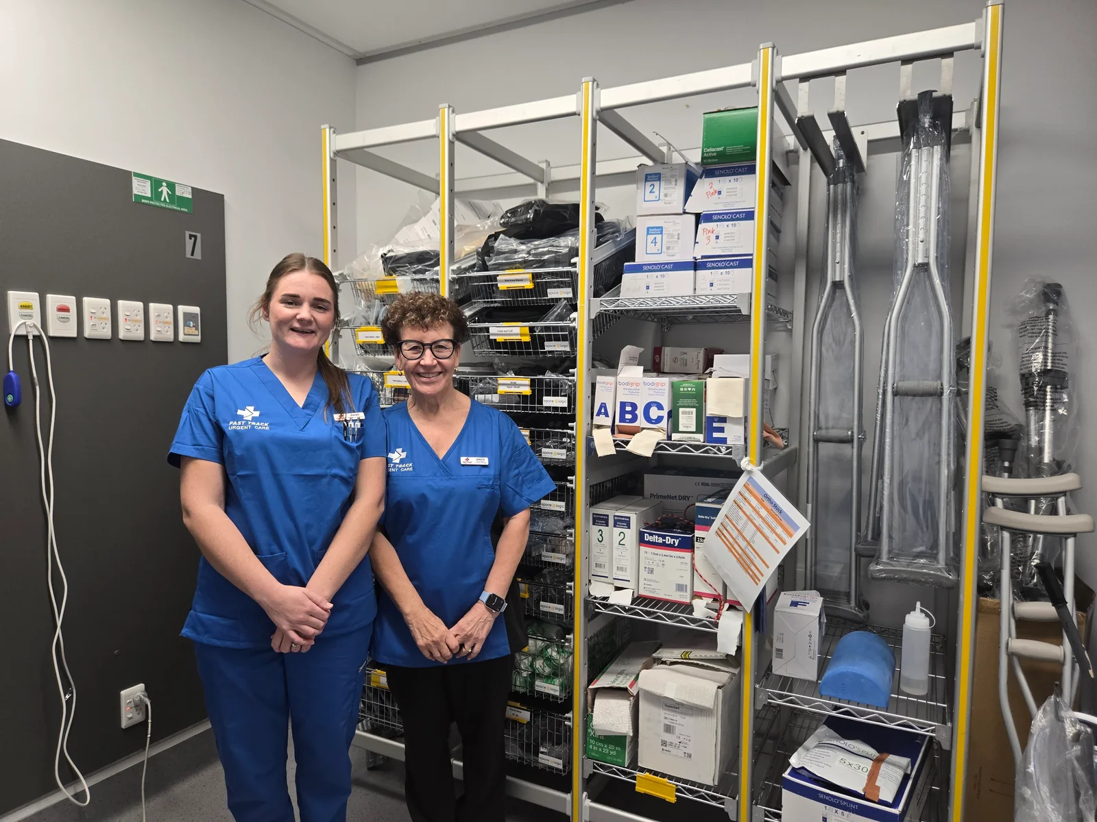 Two clinic team members beside orthopaedic supplies